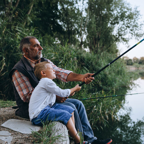 Boy-fishing-with-his-grandfather-by-the-lake